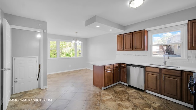 kitchen with sink, stainless steel appliances, a notable chandelier, kitchen peninsula, and pendant lighting