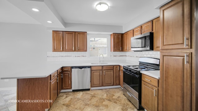 kitchen featuring tasteful backsplash, kitchen peninsula, sink, and stainless steel appliances