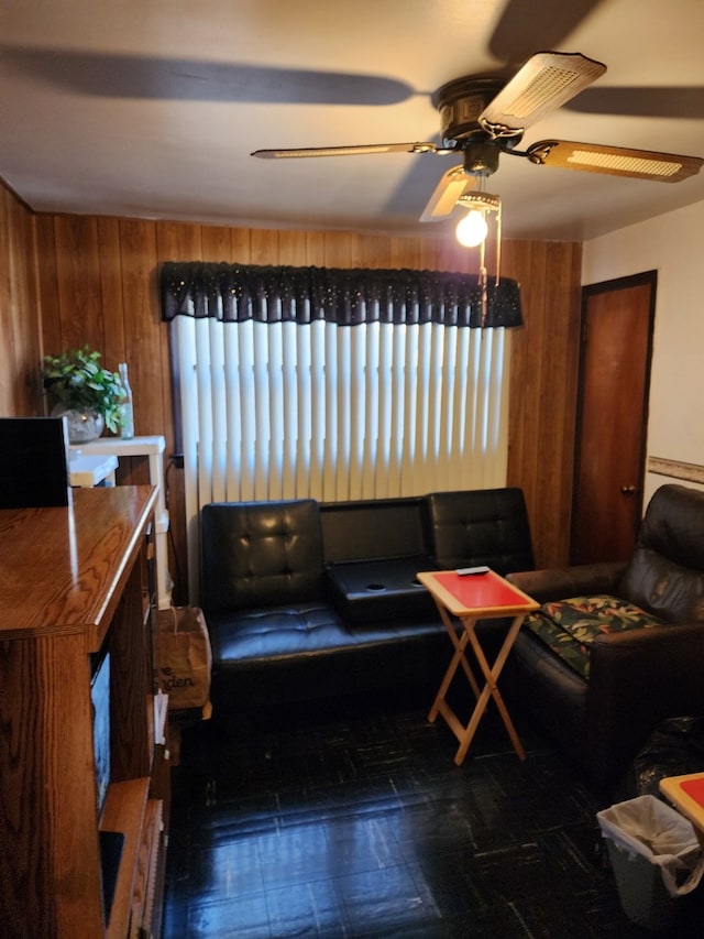 living room featuring ceiling fan and wooden walls