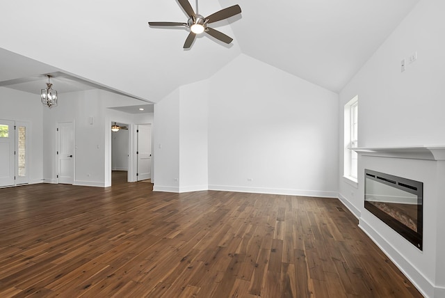 unfurnished living room featuring ceiling fan with notable chandelier, dark hardwood / wood-style floors, and lofted ceiling