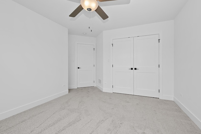 unfurnished bedroom with ceiling fan, a closet, and light colored carpet