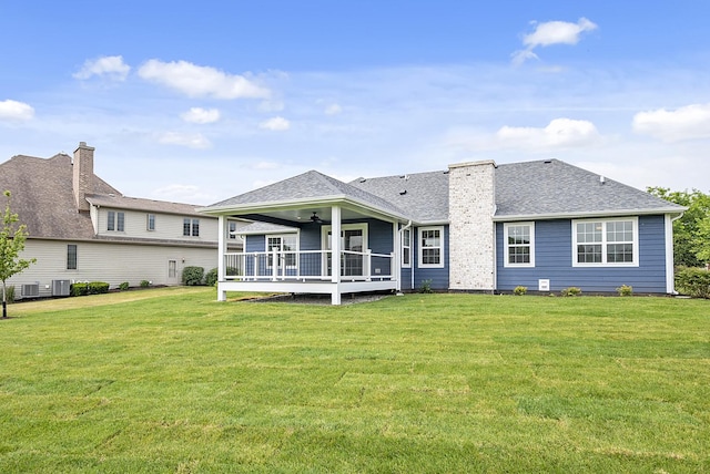 rear view of property featuring a yard and ceiling fan