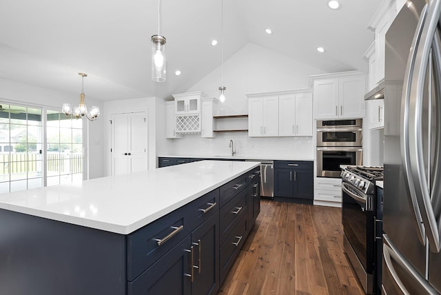 kitchen with dark hardwood / wood-style floors, decorative backsplash, decorative light fixtures, white cabinetry, and stainless steel appliances