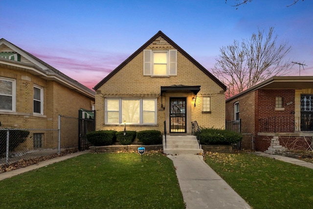 view of front facade featuring a front yard, fence, and brick siding