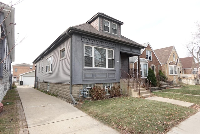 view of front of house with a garage, an outdoor structure, and a front yard