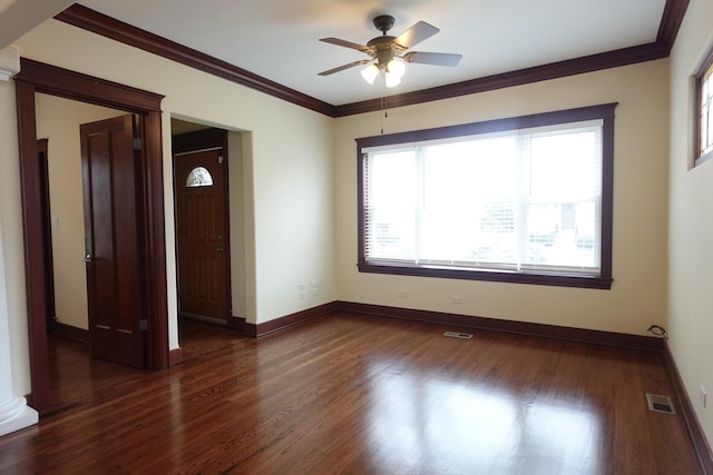 unfurnished room featuring ornate columns, ceiling fan, dark hardwood / wood-style floors, and ornamental molding