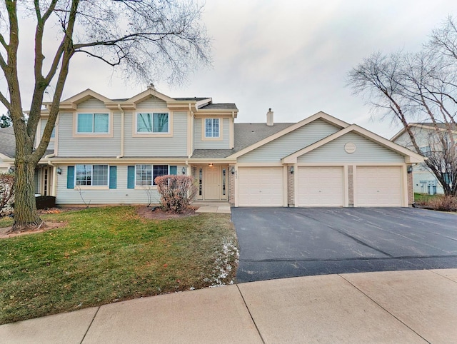 view of front of house with a garage and a front lawn