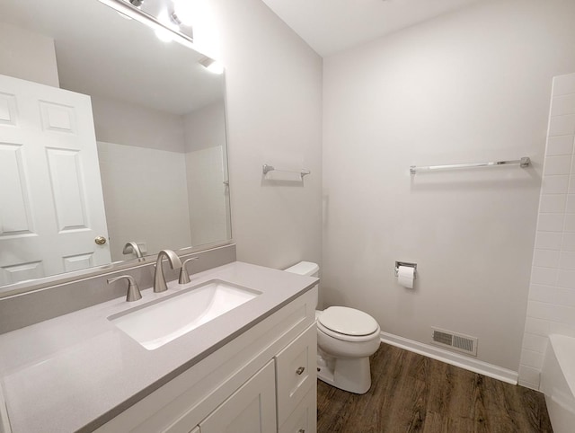 bathroom with hardwood / wood-style flooring, vanity, and toilet