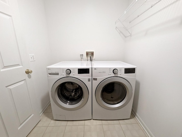 washroom with washing machine and dryer and light tile patterned floors