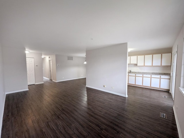 unfurnished living room with dark wood-type flooring