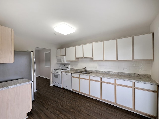 kitchen with white cabinetry, sink, dark wood-type flooring, backsplash, and white appliances