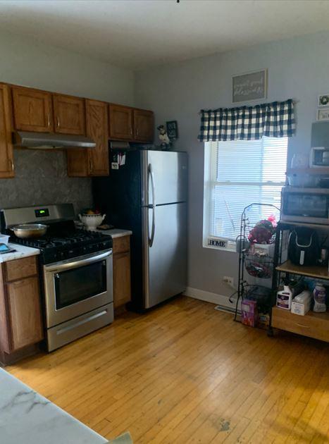 kitchen featuring decorative backsplash, stainless steel appliances, and light hardwood / wood-style floors