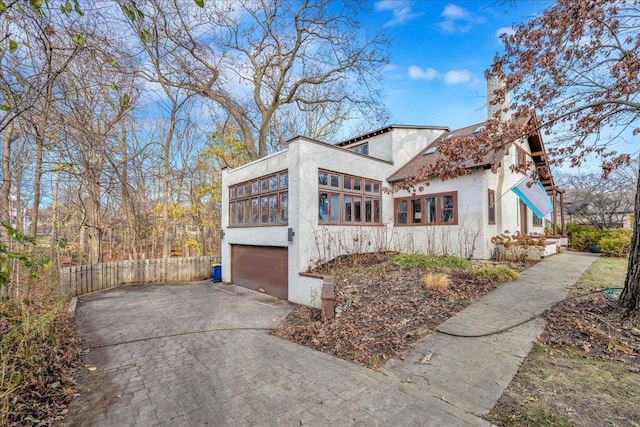 view of property exterior with a sunroom and a garage