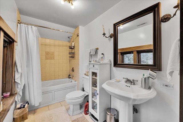 bathroom with tile patterned floors, shower / bath combination with curtain, and toilet