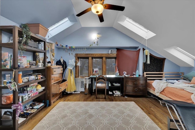 home office with lofted ceiling with skylight, ceiling fan, and dark hardwood / wood-style floors