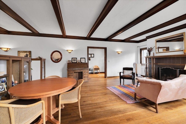 living room with beamed ceiling and light hardwood / wood-style flooring