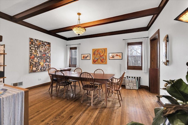 dining room with hardwood / wood-style flooring and beam ceiling