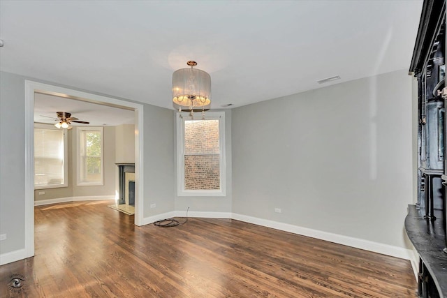 unfurnished living room with ceiling fan and dark hardwood / wood-style flooring