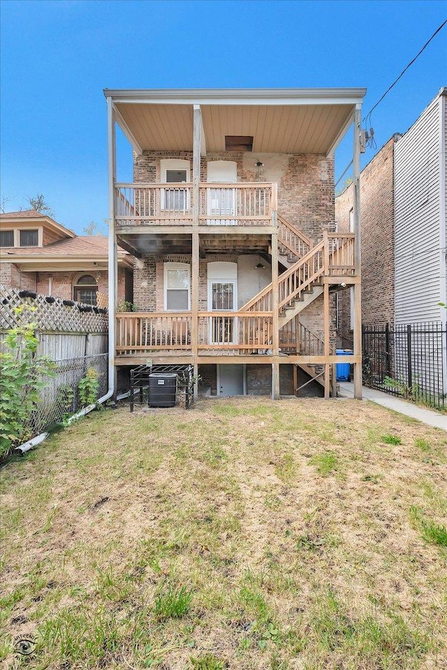 back of house with a yard and a balcony