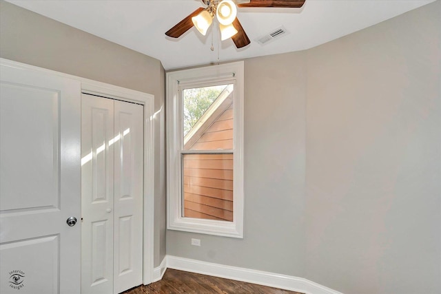 unfurnished bedroom with a closet, ceiling fan, and dark wood-type flooring