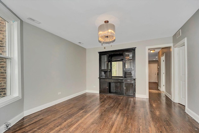 unfurnished living room with dark wood-type flooring