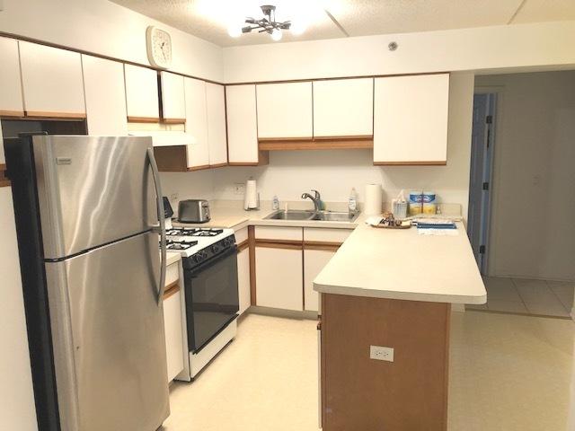 kitchen featuring white range with gas cooktop, stainless steel fridge, and sink