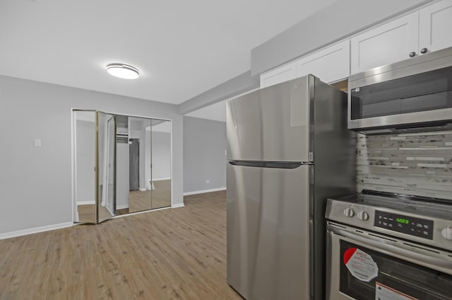 kitchen featuring white cabinetry, appliances with stainless steel finishes, and light hardwood / wood-style flooring