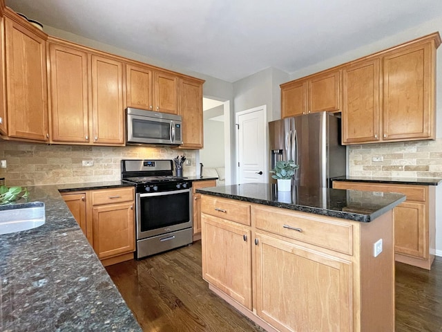 kitchen featuring backsplash, a center island, dark stone counters, dark wood-style floors, and stainless steel appliances