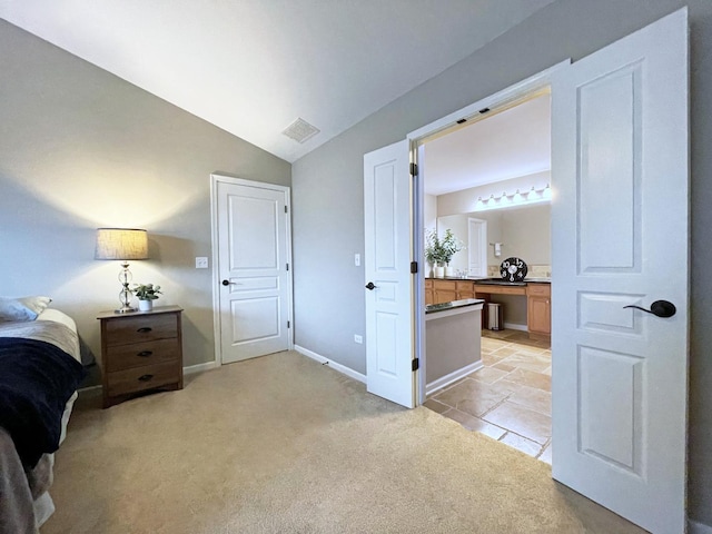 bedroom with visible vents, baseboards, lofted ceiling, light carpet, and connected bathroom