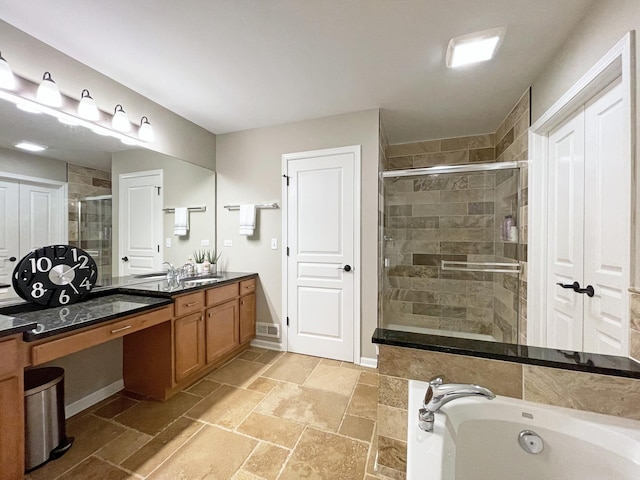 bathroom featuring a garden tub, baseboards, vanity, and a shower stall