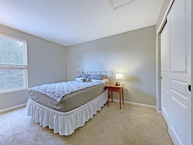 bedroom featuring baseboards, a closet, and light carpet