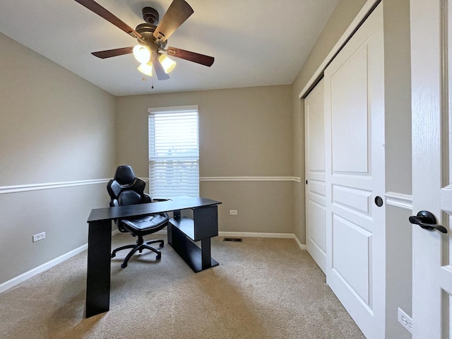 office featuring baseboards, light carpet, visible vents, and a ceiling fan