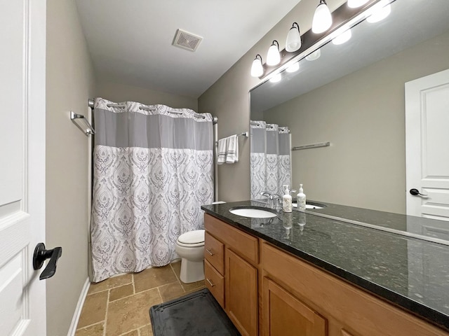 full bathroom with vanity, a shower with curtain, visible vents, stone tile flooring, and toilet