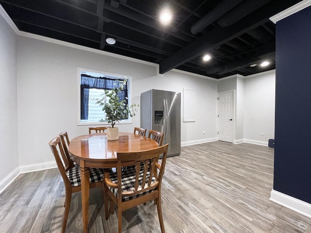 dining space with baseboards and wood finished floors