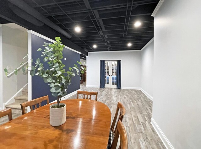 dining room featuring stairs, wood finished floors, french doors, and baseboards