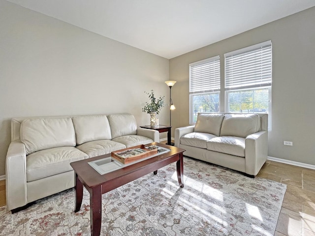 living room featuring stone tile floors and baseboards