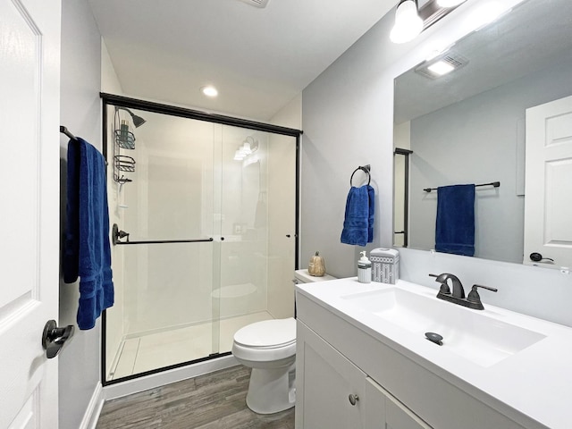 full bathroom with visible vents, a stall shower, toilet, and wood finished floors