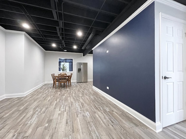 unfurnished dining area featuring baseboards and wood finished floors