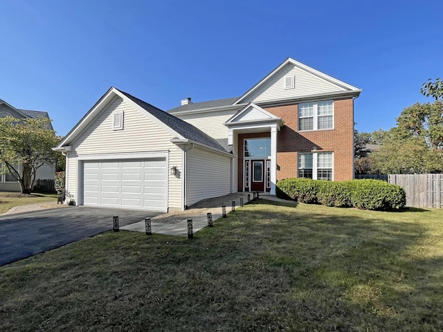 traditional-style home with a front yard, fence, driveway, an attached garage, and brick siding