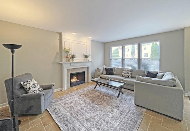 living area featuring baseboards and a fireplace