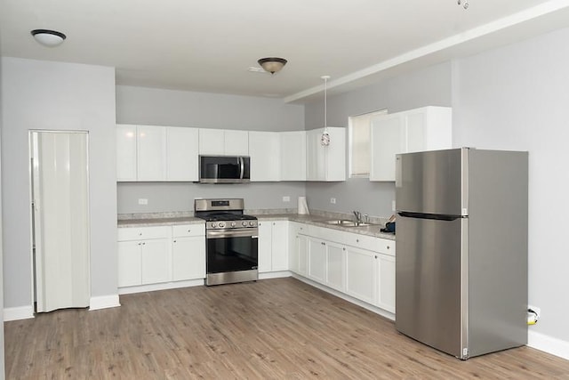 kitchen featuring white cabinetry, light hardwood / wood-style flooring, and stainless steel appliances