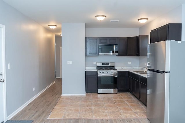 kitchen with stainless steel appliances, light hardwood / wood-style flooring, and sink