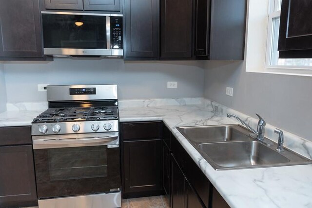 kitchen featuring sink, dark brown cabinets, and appliances with stainless steel finishes