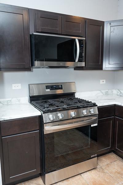 kitchen featuring dark brown cabinets, light tile patterned floors, and stainless steel appliances