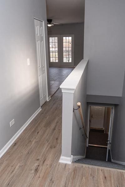 staircase with ceiling fan and wood-type flooring