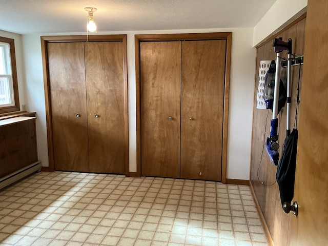 unfurnished bedroom featuring a textured ceiling and two closets