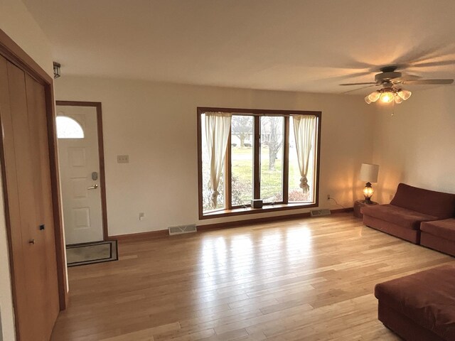 living room featuring light wood-type flooring and ceiling fan