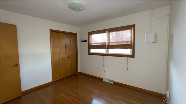 unfurnished bedroom with hardwood / wood-style flooring and a closet