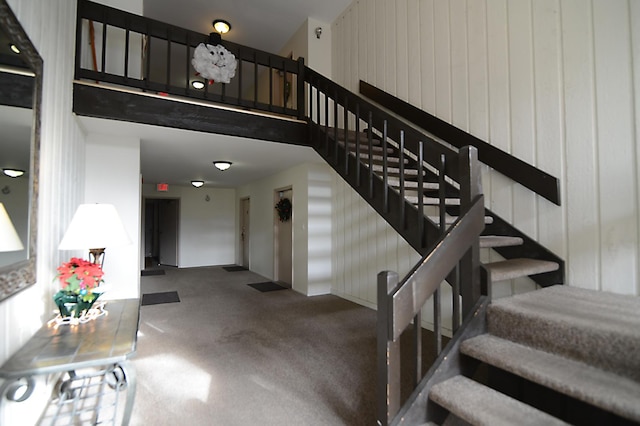 staircase featuring wood walls