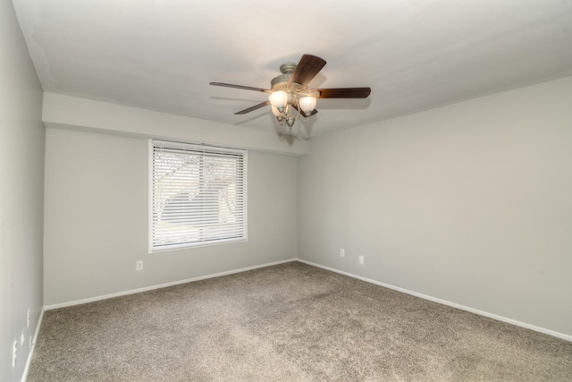 carpeted spare room with ceiling fan